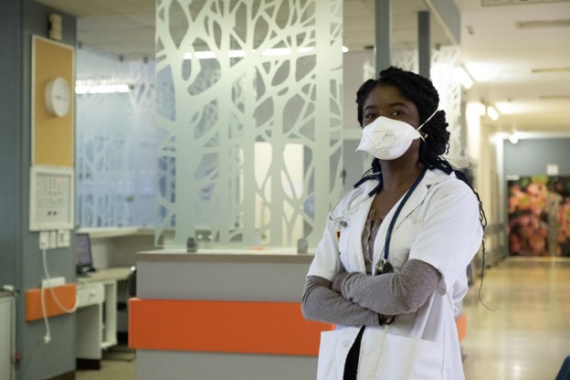 A healthcare worker standing inside a medical facility